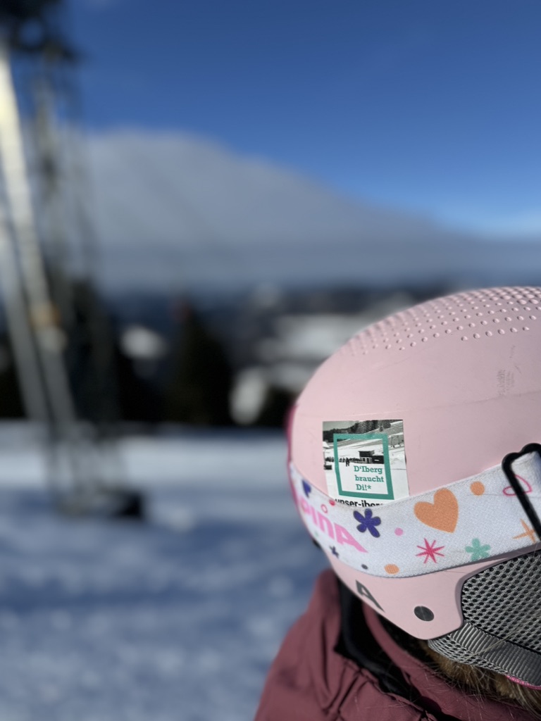Rosa Skihelm mit D’Iberg braucht Di-Aufkleber am Iberg